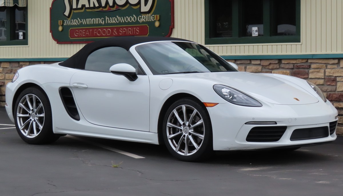 Белый Porsche 718 Boxster со сложенным верхом, вид спереди сбоку, США
