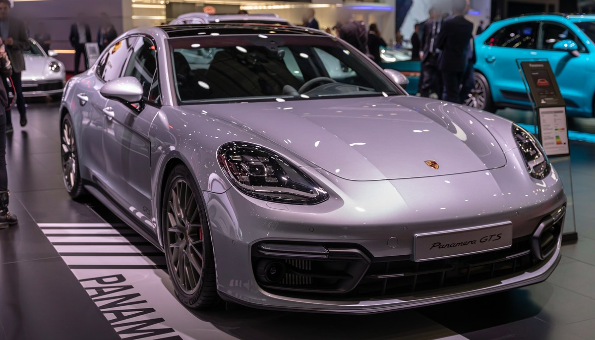 Серый Porsche Panamera GTS второго поколения, вид спереди слева в три четверти, на автосалоне