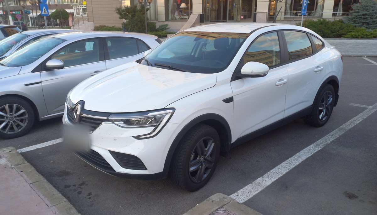 Белый Renault Arkana, вид спереди в три четверти, на парковке