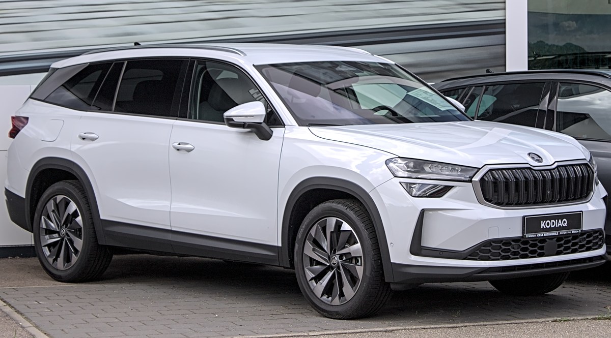 Белый Skoda Kodiaq второго поколения, вид спереди в три четверти, у дилерского центра