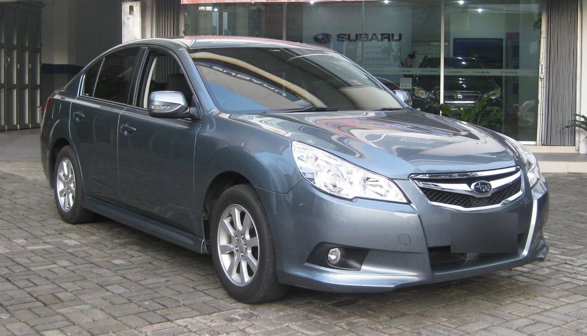 Серо-зелёный седан Subaru Legacy пятого поколения (BM), вид спереди-справа, у дилерского центра Subaru
