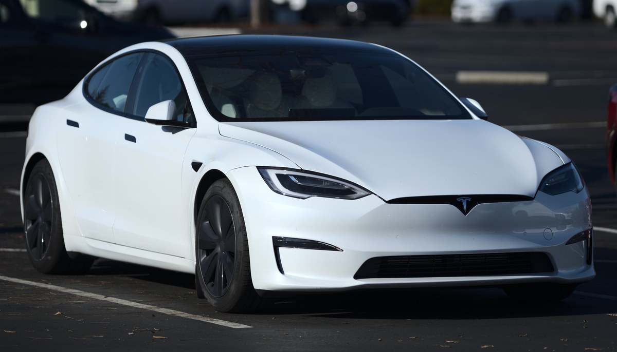 Белая Tesla Model S после обновления 2021 года, вид спереди справа в три четверти, на парковке