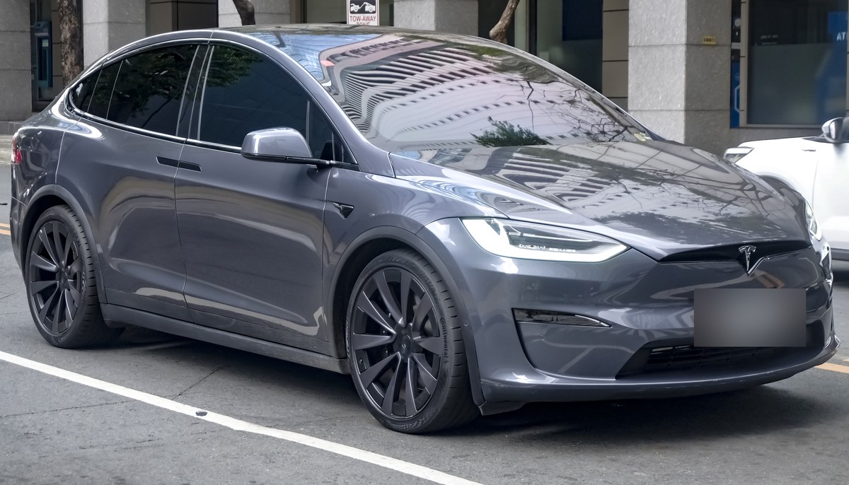 Серая Tesla Model X Plaid после обновления 2021 года, вид спереди в три четверти, на городской улице