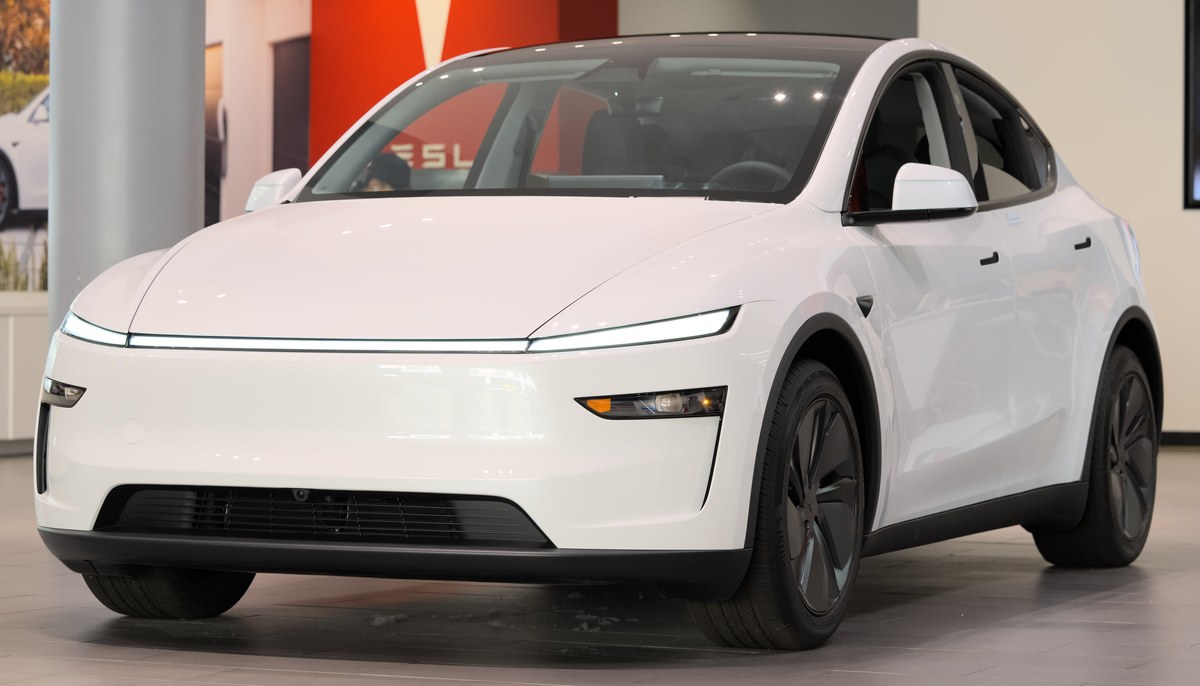 Белая Tesla Model Y после обновления Juniper, вид спереди в три четверти, в салоне-магазине Tesla