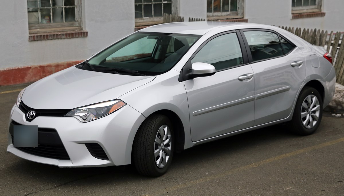 Серебристая Toyota Corolla E170 седан, вид спереди в три четверти