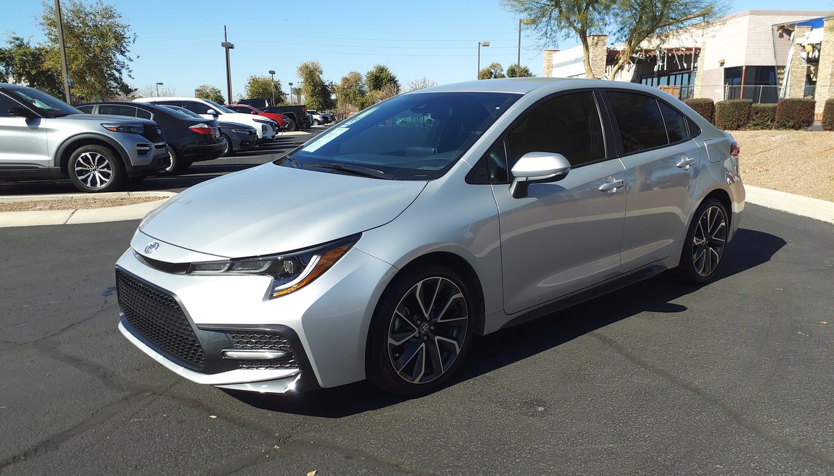 Серебристая Toyota Corolla E210 седан, вид спереди в три четверти