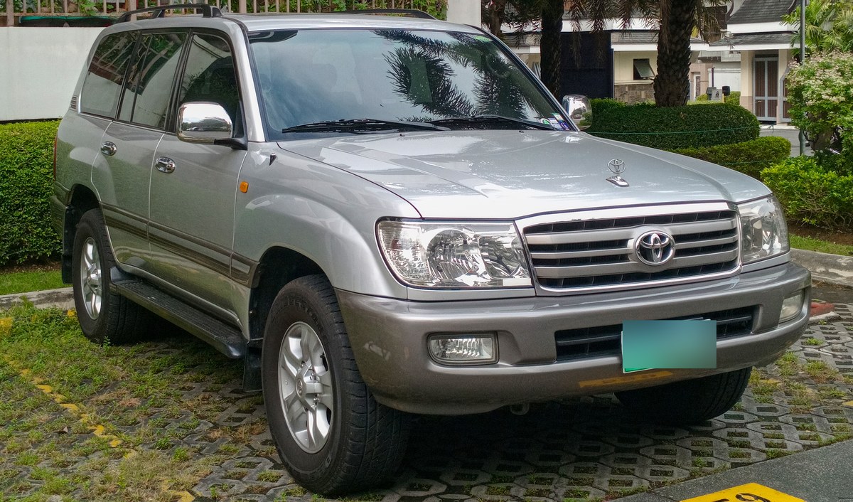 Серебристый Toyota Land Cruiser 100 на парковке, вид спереди в три четверти