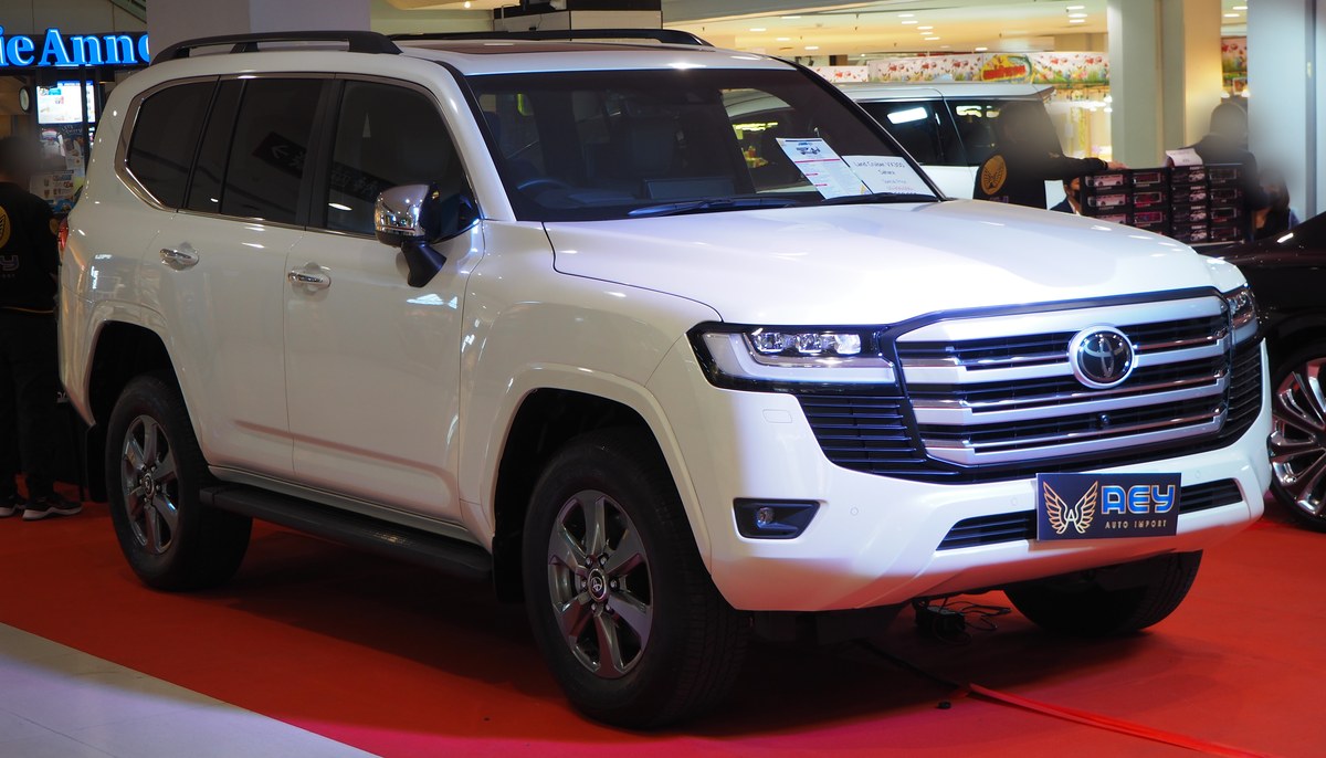 Белый Toyota Land Cruiser 300 на выставке, вид спереди в три четверти