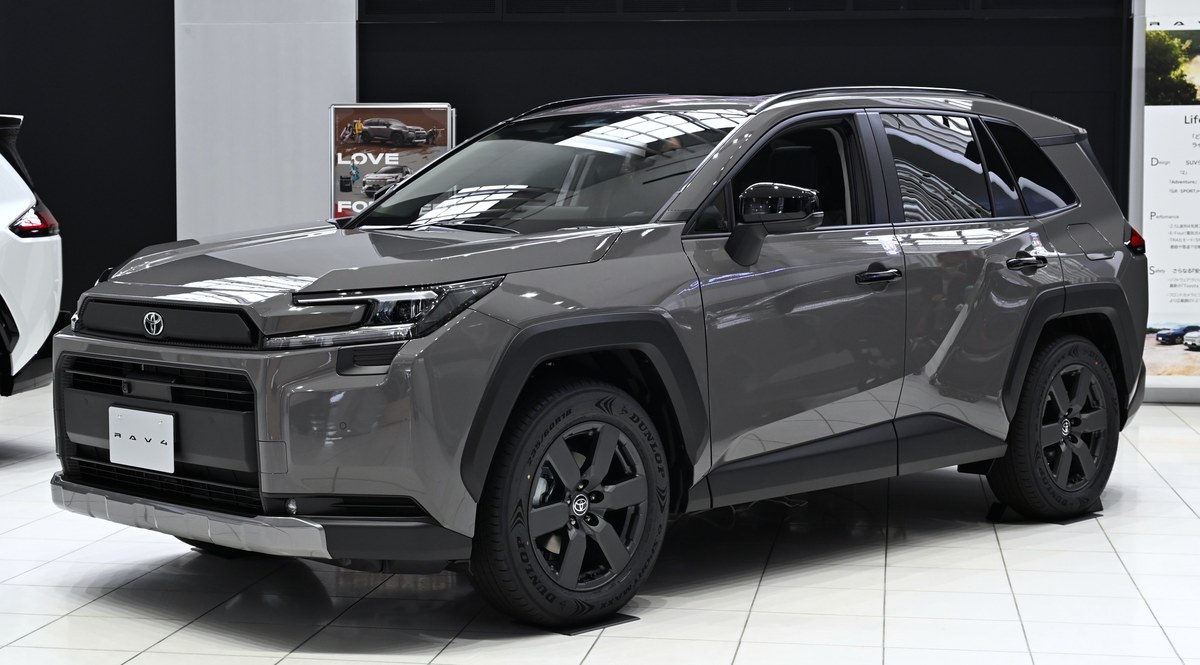 Тёмно-серый Toyota RAV4 шестого поколения (XA60) Hybrid Adventure, вид спереди в три четверти, в выставочном зале
