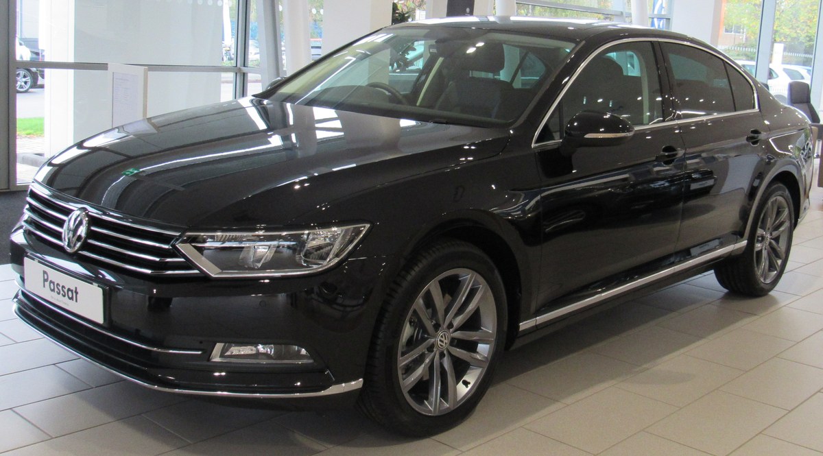 Чёрный Volkswagen Passat B8 седан 2017 года в салоне дилера, вид спереди в три четверти