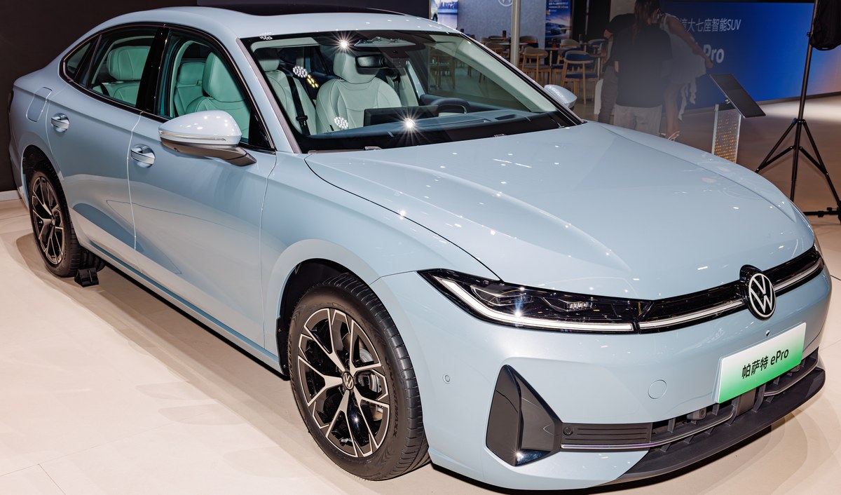 Голубой седан Volkswagen Passat нового поколения для Китая на выставочном стенде, вид спереди