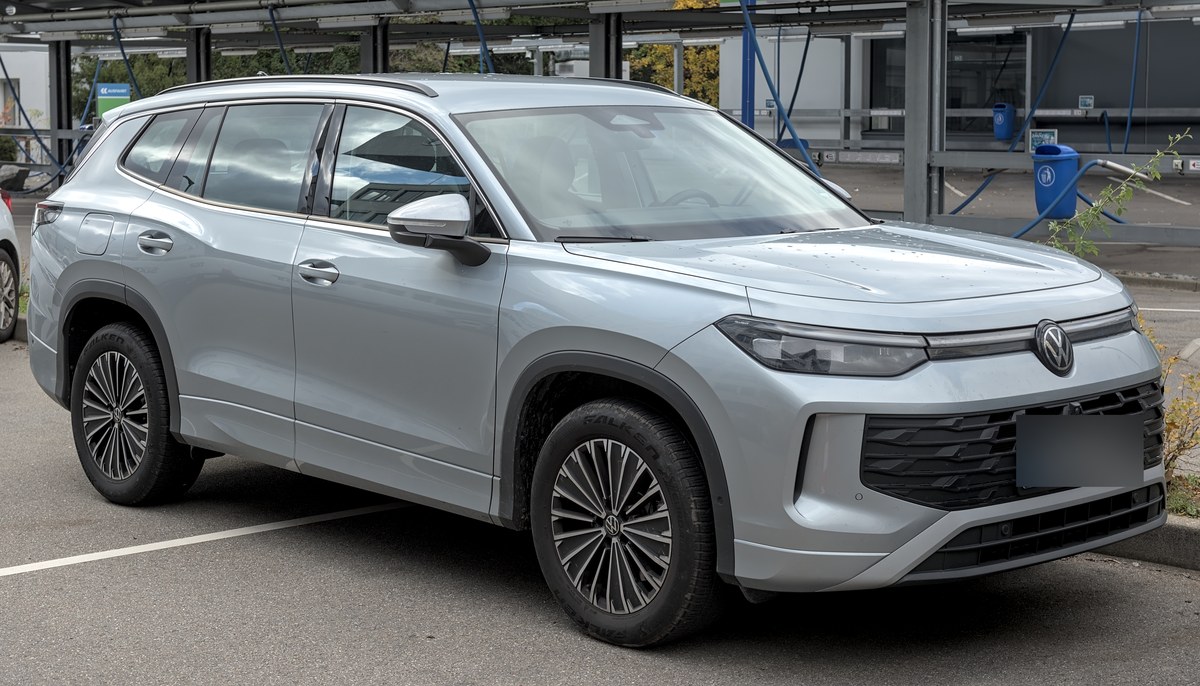 Серебристый Volkswagen Tayron второго поколения с длинной базой, вид спереди сбоку на парковке