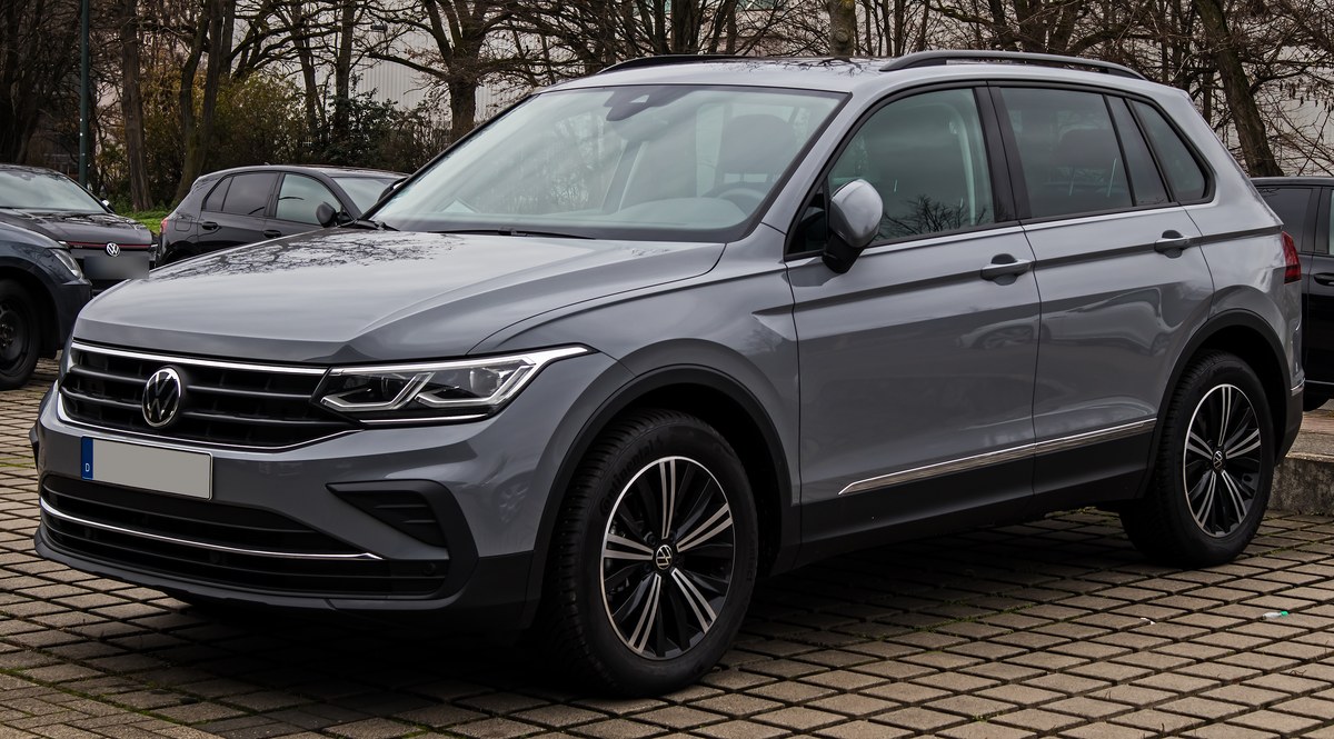 Серый Volkswagen Tiguan второго поколения после рестайлинга, вид спереди сбоку на парковке