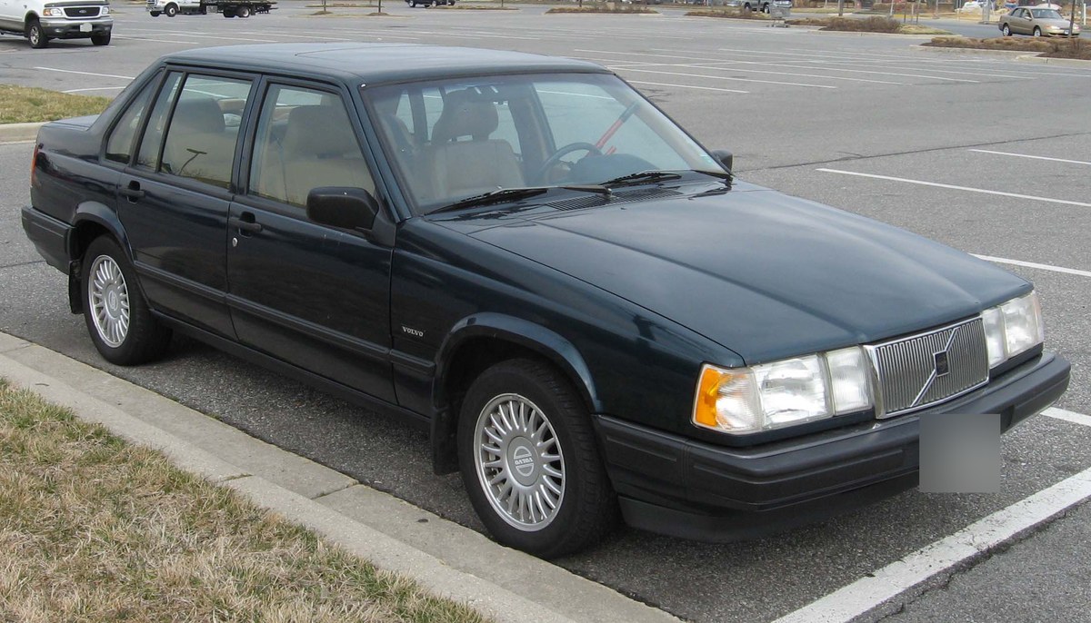 Тёмно-зелёный седан Volvo 940, вид спереди в три четверти